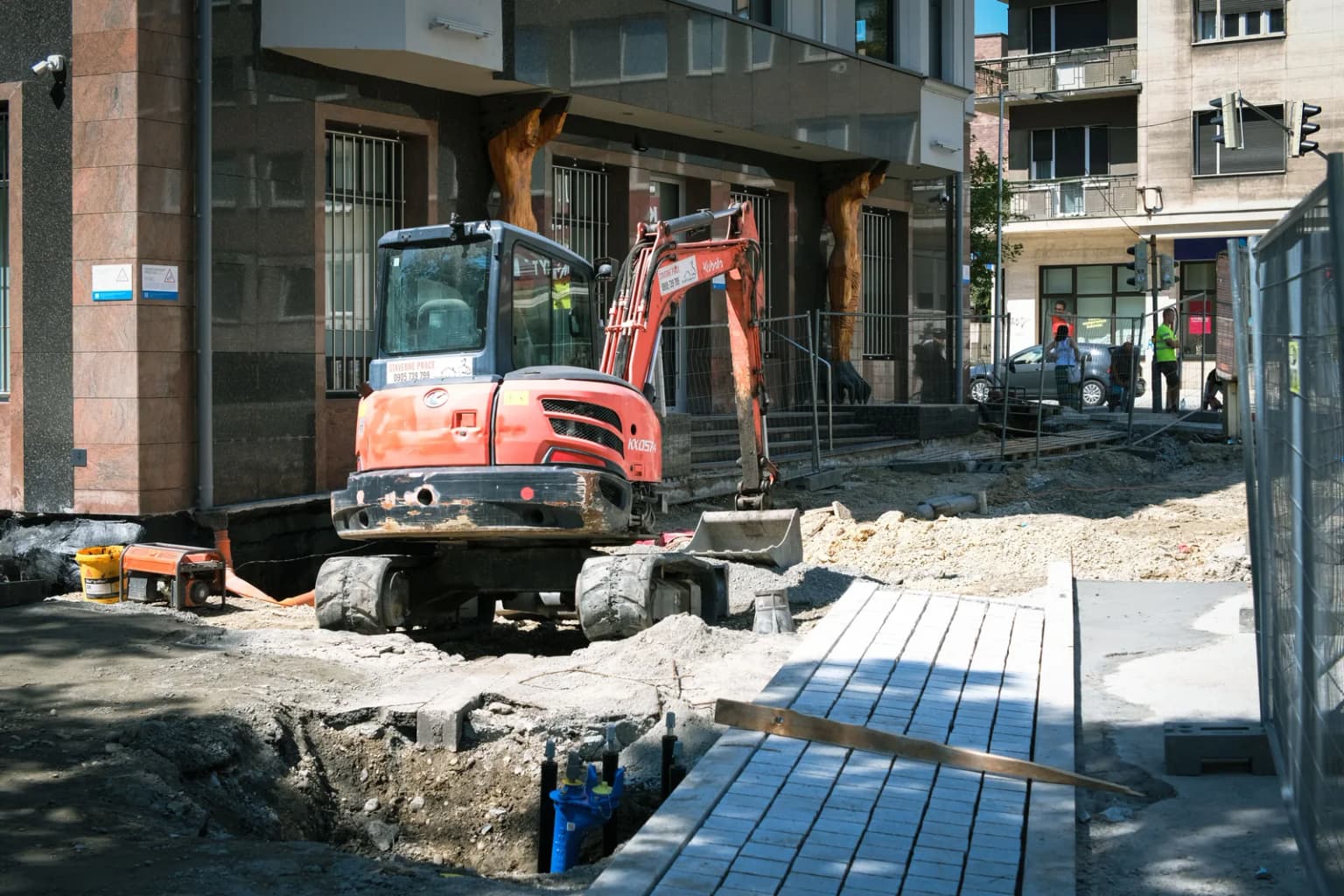 Koparka przy wykopie pod odwodnienie drogi i parkingu